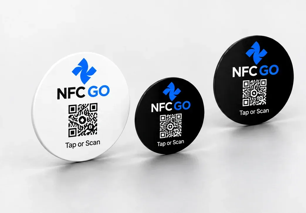 Three NfcGo tags on a table, one white and two black
